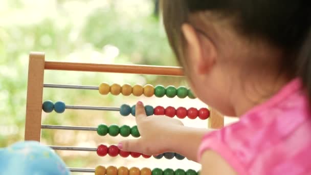 Aranyos testvér gyermek lányok tanulás számolás oktatási színes fa abacus a kertben. Óvodáskorú gyerekek otthoni iskolai koncepcióval. - Felvétel, videó