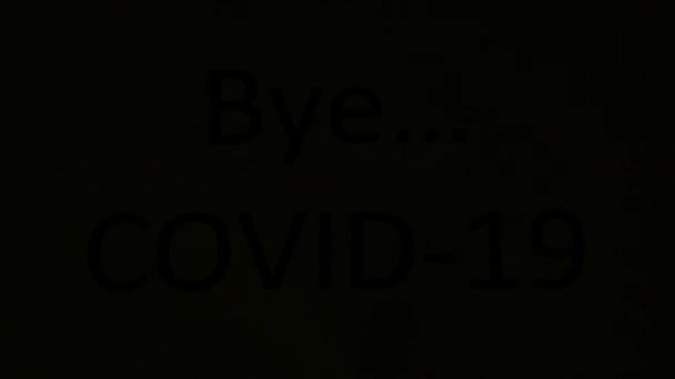 Światło świeci na papierze o nazwie Bye COVID 19. Pożegnanie się z pandemią wirusa Corona. - Materiał filmowy, wideo
