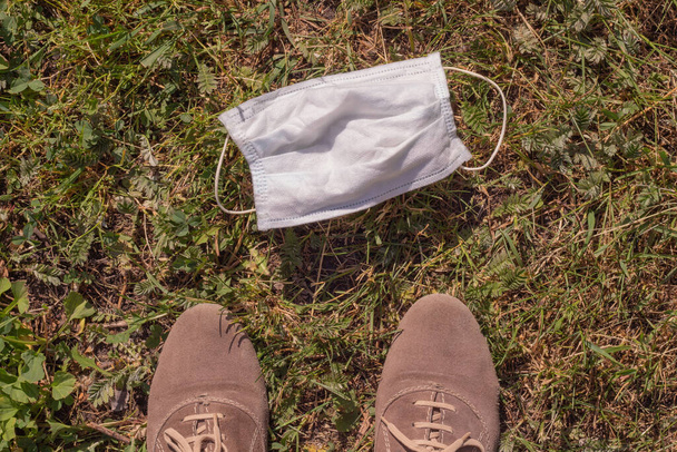 medisch masker en schoenen op het gras. Concept einde quarantaine en zelf-isolatie - Foto, afbeelding