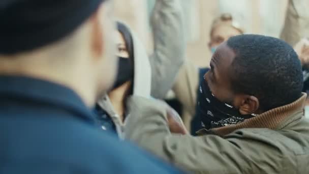 Gros plan d'un manifestant afro-américain criant et criant sur un policier lors d'une manifestation pour les droits humains. Manifestants américains se battant et se disputant avec un flic pour protester contre la violence policière. - Séquence, vidéo