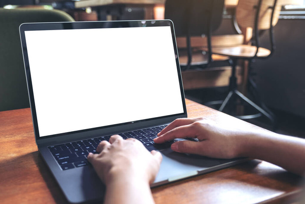 Образец изображения рук, использующих и печатающих на ноутбуке с белым экраном на деревянном столе в кафе
 - Фото, изображение