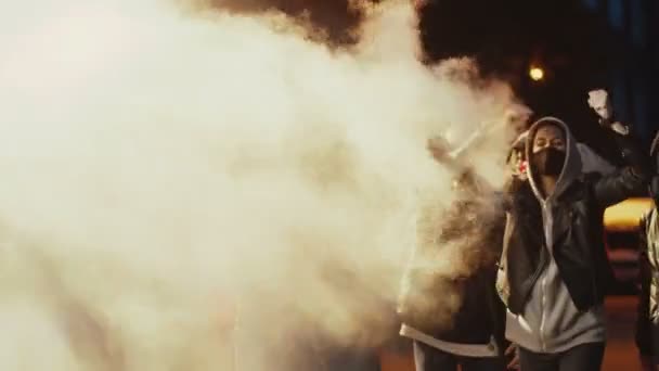 Mężczyzna i kobieta młody wieloetniczny protestujący w dym krzyczący motto i hasło dla czarny człowiek godność przy manifestacja dla prawo Afroamerykanin. Demonstracja w USA na ulicy jednej nocy. - Materiał filmowy, wideo