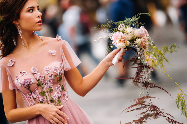 A young beautiful bride stands at the center of the Old city of Florence in Italy. Bride in a beautiful pink dress with a bouquet in Tuscany.Italy. - Foto, Bild