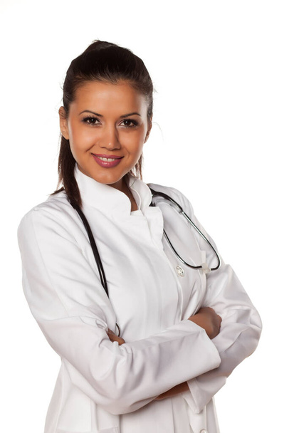 young beautiful nurse with arms folded on white - Foto, Imagem