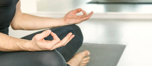 Yoga calm pose. Lotus asana at studio training. Man seated at mat. Beginner - Valokuva, kuva