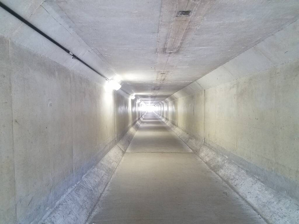 długi szary tunel cementowy ze światłem przy wyjściu - Zdjęcie, obraz