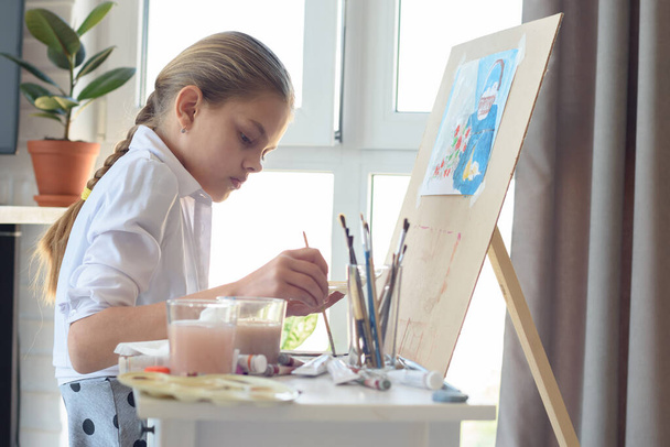 Young artist draws in the studio behind an easel - Photo, Image