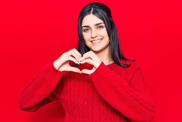 Young beautiful girl wearing casual sweater smiling in love doing heart symbol shape with hands. romantic concept.  - Photo, Image
