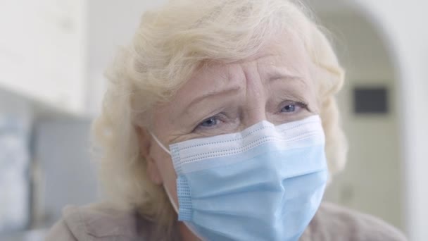 Sad woman in mask looking at camera, self-isolation for elderly people, lockdown - Materiał filmowy, wideo