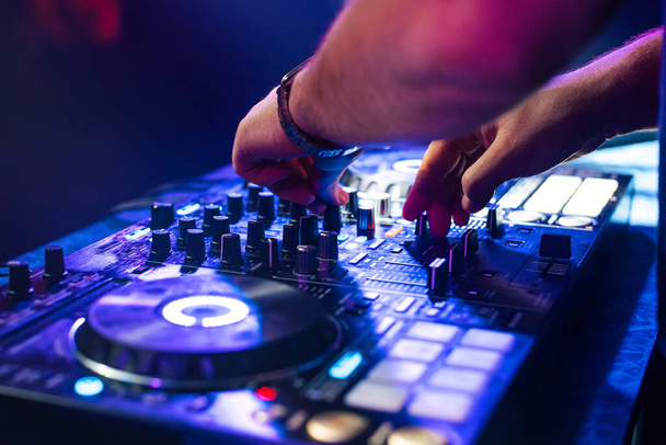 DJ hands mix music on a mixing Board in a nightclub - Fotoğraf, Görsel