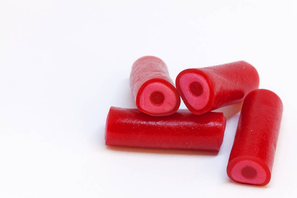 vier rote Bonbons, die länglich sind und Himbeere schmecken - Foto, Bild