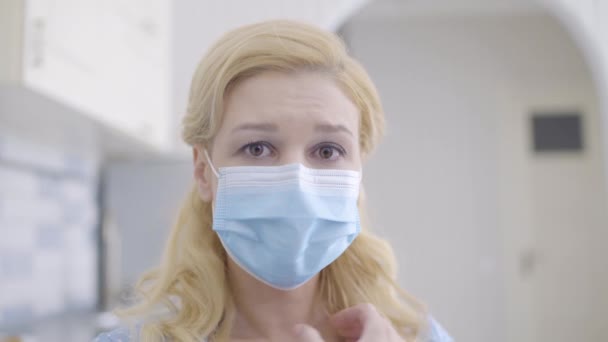 Crying young female in mask looking at camera, scared of dangerous disease - Filmagem, Vídeo