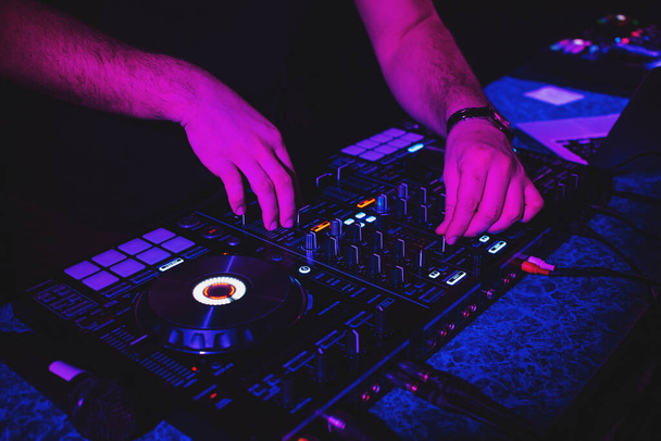 DJ joue de la musique avec ses mains sur un contrôleur mélangeur - Photo, image