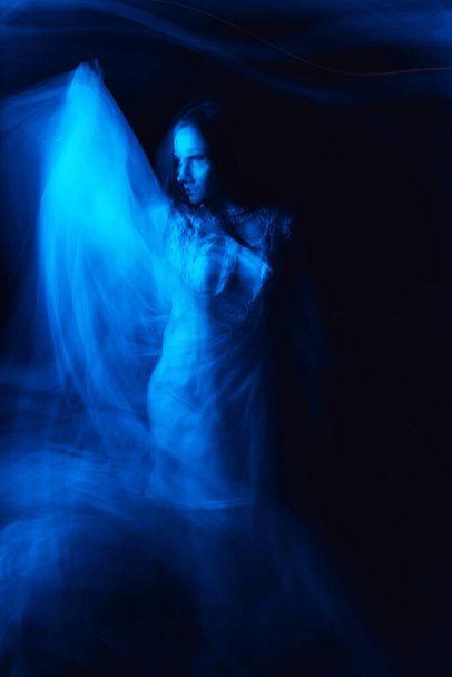 mystical silhouette of a Ghost of a witch girl in a dress on a dark background - Photo, image