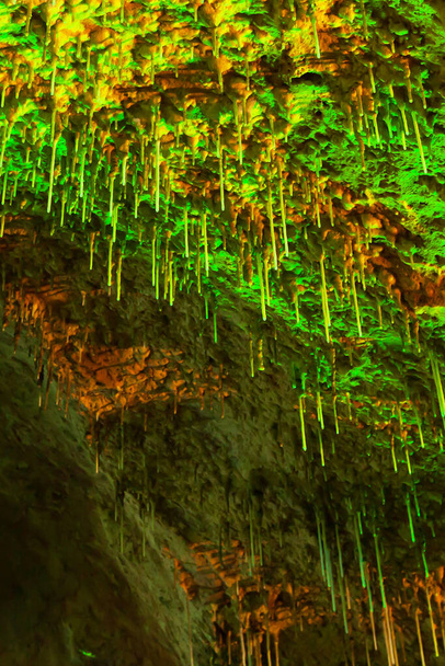 Magiczne wnętrze starożytnej jaskini wapiennej, fantastyczny zielony stalagmit świecący w światłach. Jaskinia Khao Bin, Ratchaburi, Tajlandia. Widok z niskiego kąta. - Zdjęcie, obraz