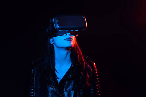 menina em óculos de realidade virtual moderna em um fundo preto - Foto, Imagem