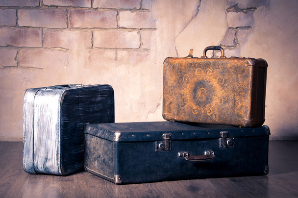Old suitcases on the brick wall background. - Zdjęcie, obraz