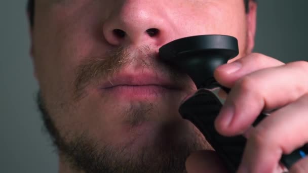 hombre se afeita el bigote con una navaja eléctrica
 - Metraje, vídeo