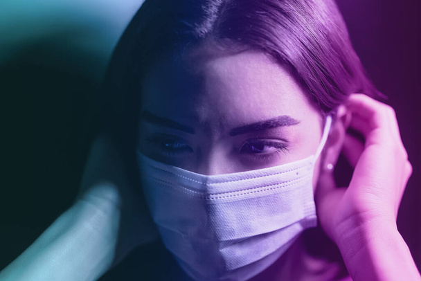 Young woman wearing face surgical mask against corona virus - Fear girl quarantine for preventing pandemic spread of coronavirus - Mental health impact during covid19 and anxiety people concept - Photo, Image
