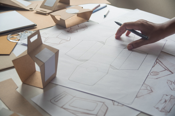 Designer sketching drawing design Brown craft cardboard paper product eco packaging mockup box development template package branding Label . designer studio concept . - Fotó, kép