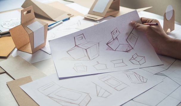 Designer sketching drawing design Brown craft cardboard paper product eco packaging mockup box development template package branding Label . designer studio concept . - Foto, afbeelding