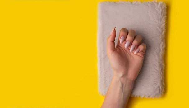 Female hands with a beautiful manicure on a yellow background,top view,flat lay. Manicure concept,banner - Foto, Imagem