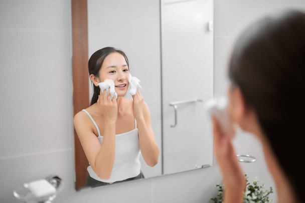 Asijské ženy dospělý čištění obličeje v horké vodě doma na ráno. Užívám si relaxační čas. - Fotografie, Obrázek