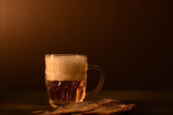 黒を背景にビールマグカップや干物。オクトーバーフェストのコンセプト - 写真・画像