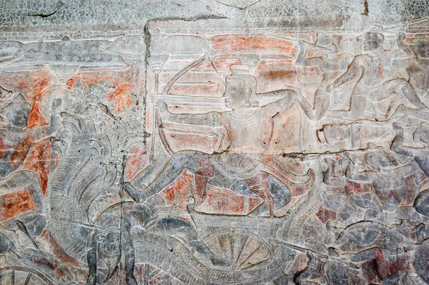 Antiguo tallado en relieve Khmer bas que muestra al dios hindú Shiva disparando una flecha desde un carro tirado por un Naga - un dios serpiente de muchas cabezas. Pared del templo de Angkor Wat, Siem Reap, Camboya
. - Foto, Imagen