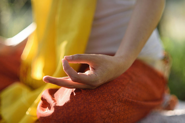 Detalle de la mano de mujer en pose de mudra en meditación al aire libre
. - Foto, Imagen