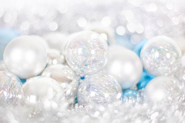 Christmas and New Year pattern, ornament of Christmas balls and tinsel, winter decor in blue and white color, blurred bokeh background close up - Photo, Image