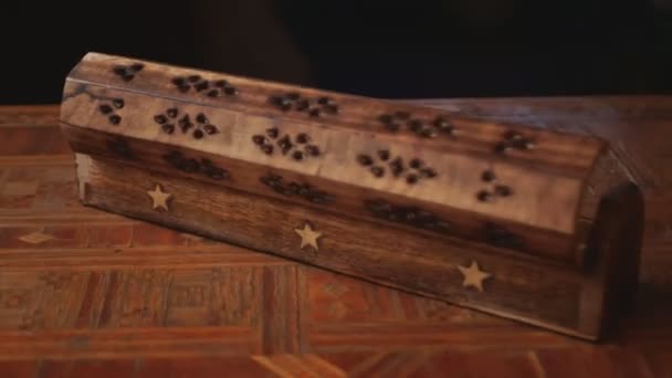 Coffin de madera Incienso Palo Conos quemador y palos titular Caja en una mesa de madera hecha a mano, gira en el sentido de las agujas del reloj. Fondo negro - Imágenes, Vídeo