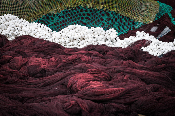 Κοντινό πλάνο πράσινων και καφέ διχτυών ψαριών και παγίδων που στεγνώνουν στις ακτές της Γαλικίας το σούρουπο, Ισπανία. - Φωτογραφία, εικόνα