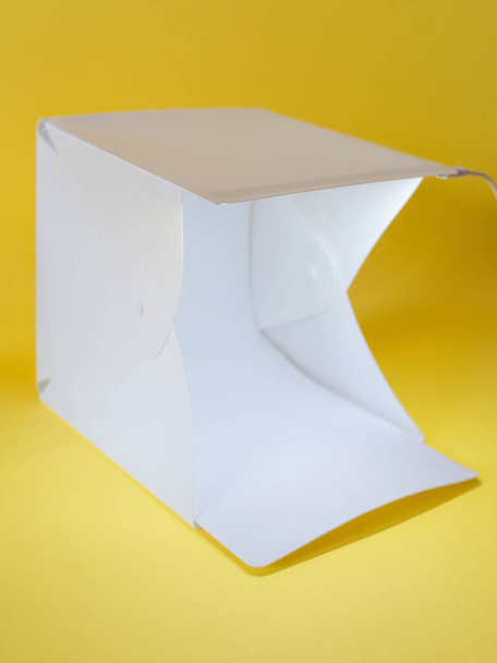 light cube on yellow background. Light, work, hobby, photographer concept - Photo, Image
