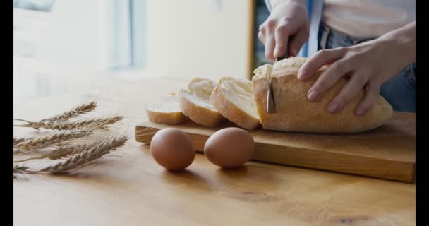 Nainen leikkaa rapea leipä maalaismainen pöytä - Materiaali, video