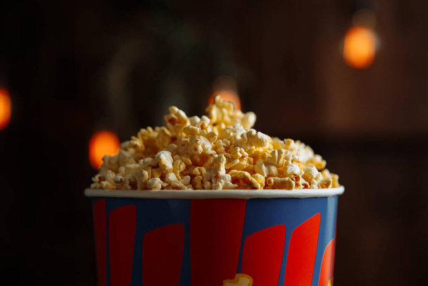 Popcorn dans une boîte lumineuse isolée sur fond en bois. Vue rapprochée - Photo, image