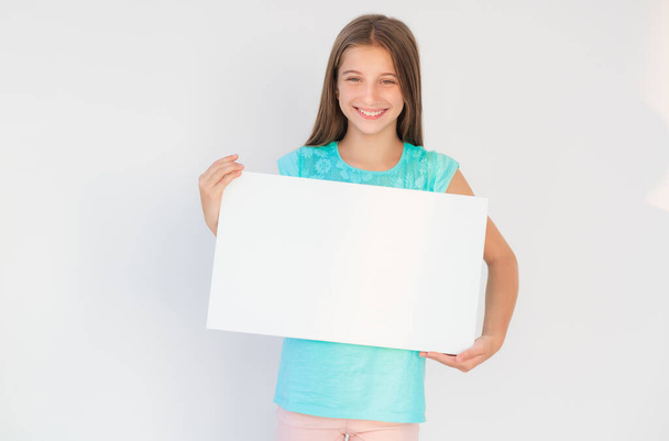 Young girl showing white canvas with copy space - Foto, immagini