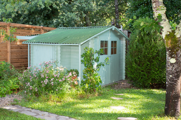 cabana de jardim casa de madeira verde na parte inferior do parque da casa
 - Foto, Imagem