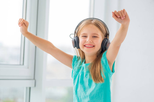Happy little girl in headphones - 写真・画像