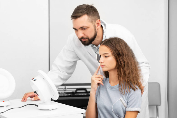 Okulista bada nastolatkę w klinice - Zdjęcie, obraz