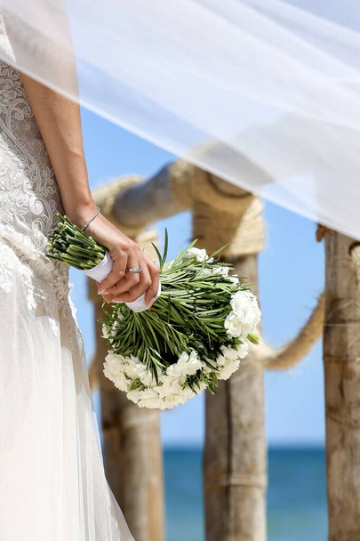 γαμήλια ανθοδέσμη λουλούδια στο χέρι νύφη στην τελετή - Φωτογραφία, εικόνα