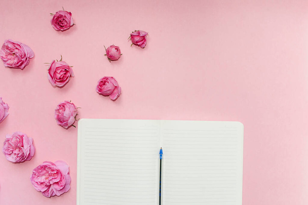 Offenes Notizbuch, rosa Hintergrund mit Blumen. Attrappe auf. Postkartenvorlage. Platz für Text - Foto, Bild