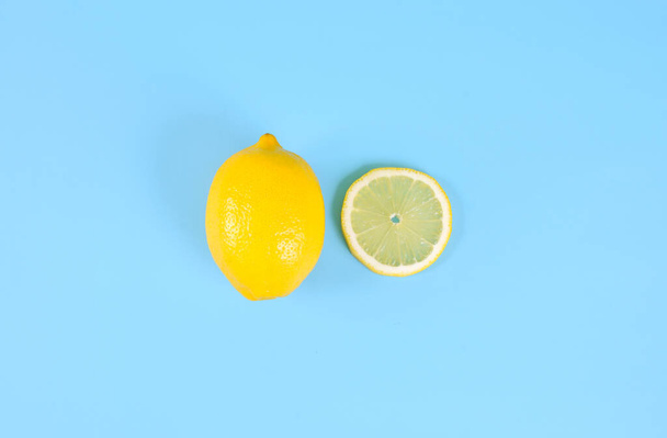 Slices and whole lemon on blue background, top view - Photo, Image
