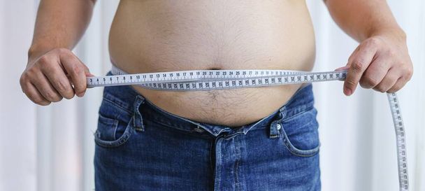 Man met dikke buik in dieetconcept. Overgewicht man aanraken van zijn dikke buik en willen gewicht te verliezen - Foto, afbeelding