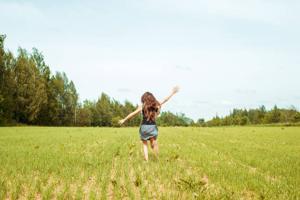 Kid girl jumping on the grass at spring.Summer field, horizon and sky. Happy childhood and freedom. Life Style Outdoors - Zdjęcie, obraz