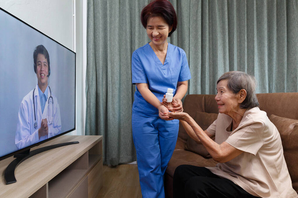 Пожилая женщина сидит дома и консультируется с врачом онлайн - Фото, изображение