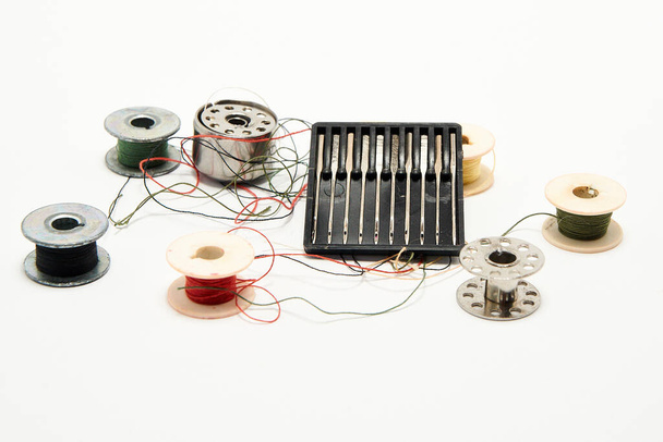 Conjunto de agulhas e fios para uma máquina de costura em um fundo branco
 - Foto, Imagem