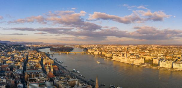 Vista de la puesta de sol de los aviones teledirigidos del Parlamento húngaro por el río Danubio durante la hora de oro en invierno. - Foto, imagen
