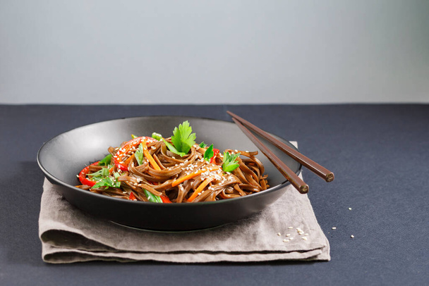 tradiční japonské nudle se zeleninou na talíři na stole - Fotografie, Obrázek