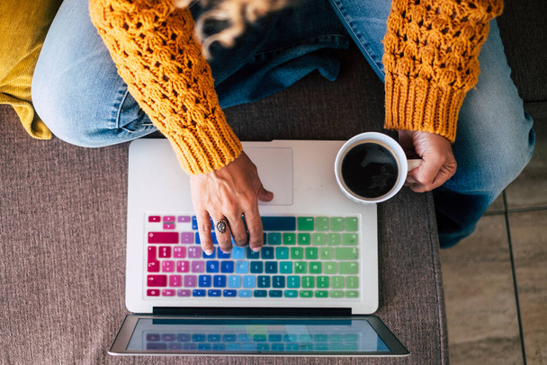 Взрослые женщины работают и пишут на цветной клавиатуре ноутбука, пока пьют кофе
 - Фото, изображение